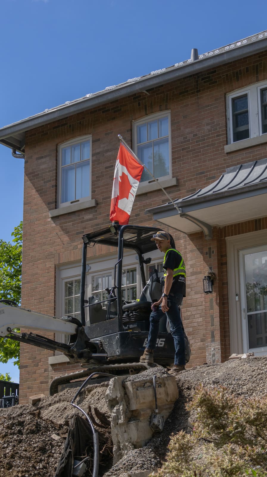 RMAK excavator digging with a Canadian flag